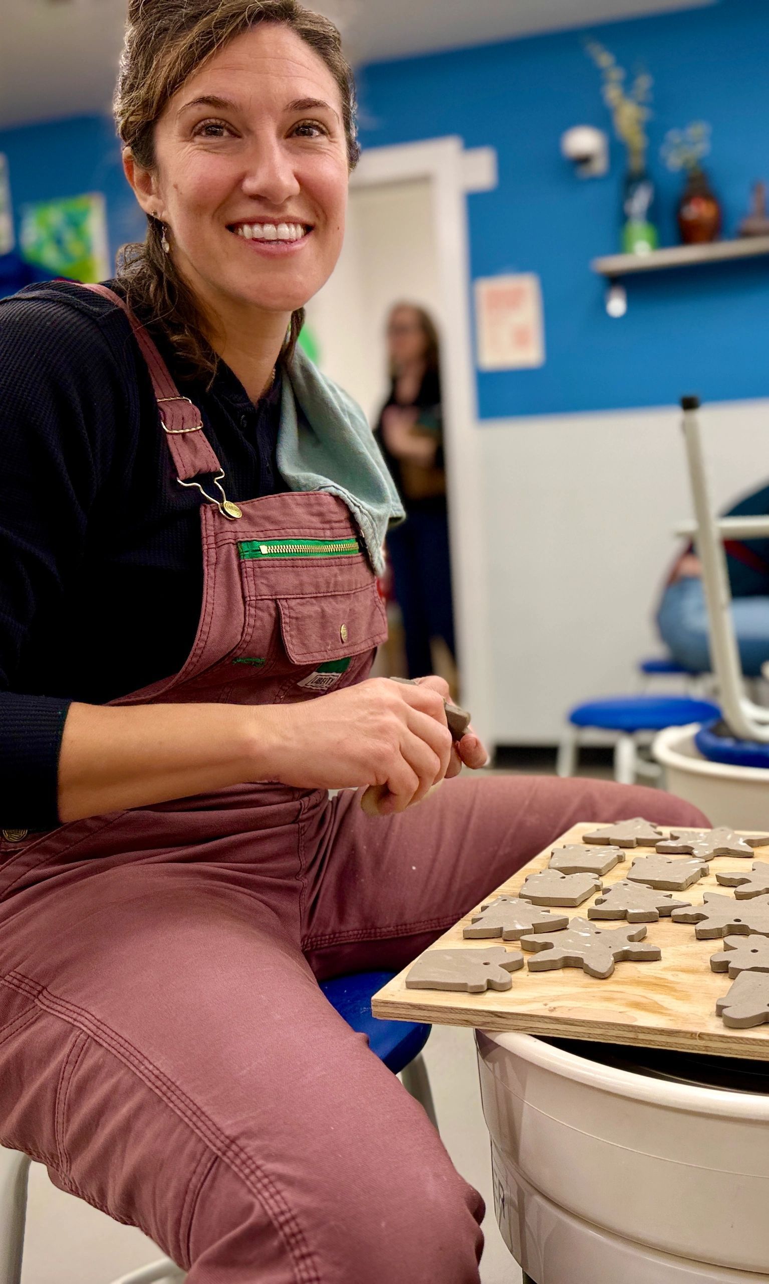 Smiling instructor in overalls at Portside studio